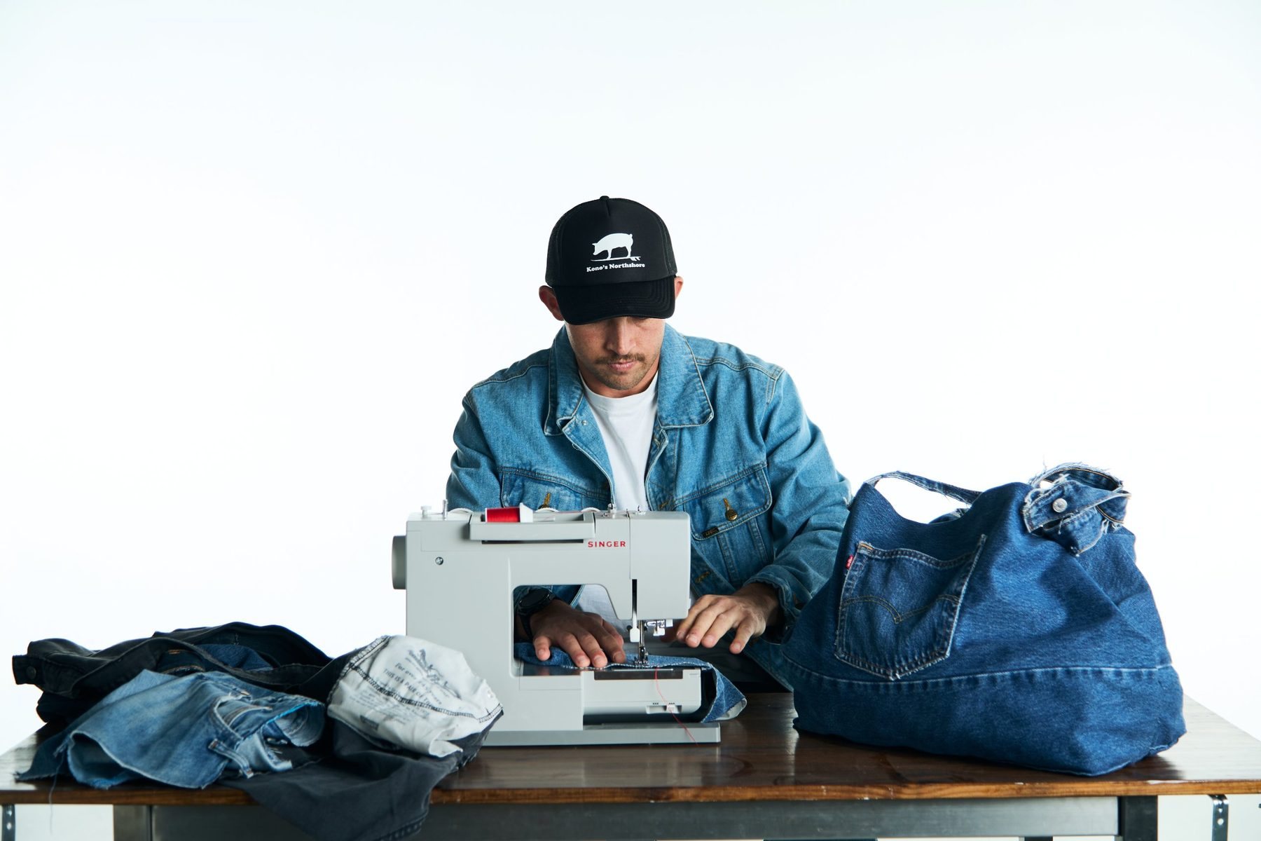Maker sewing a denim bag at a sewing machine